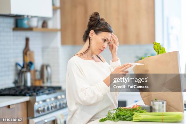 woman reviewing grocery bill - adding machine tape stock pictures, royalty-free photos & images