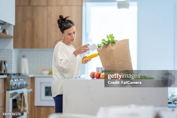 woman reviewing grocery bill - adding machine tape stock pictures, royalty-free photos & images