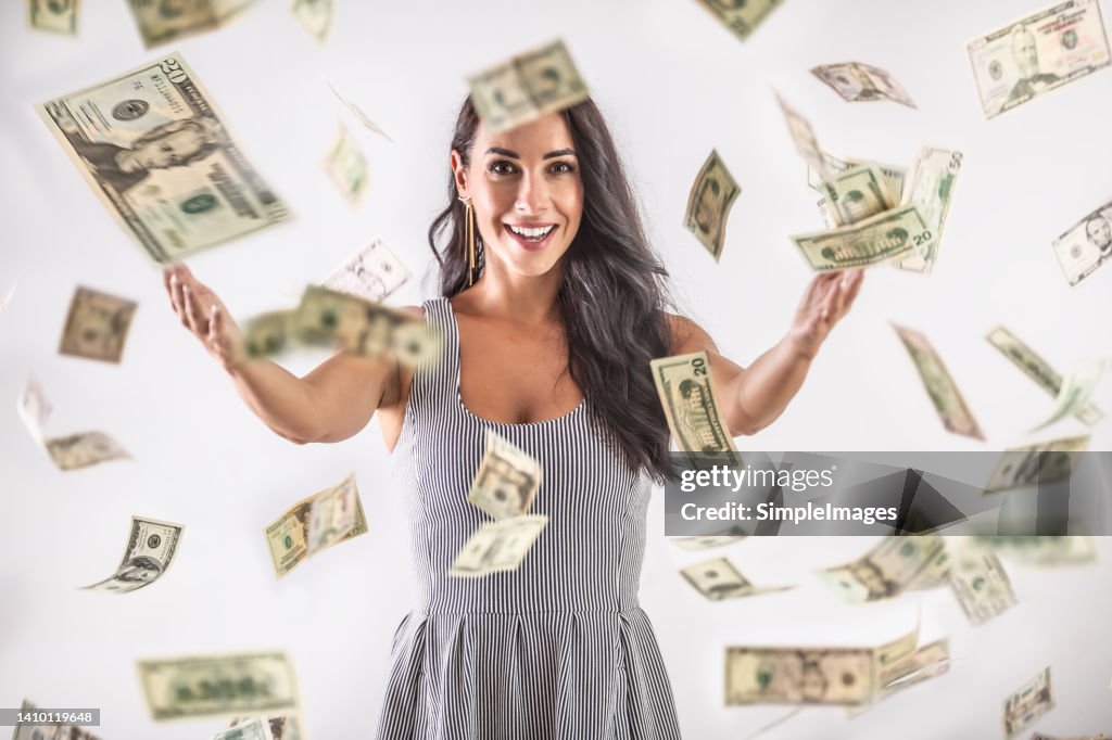 A young woman is throwing around a lot of dollar bills. Lottery winning concept.