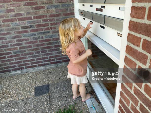 kleinkind, das den briefkasten überprüft - girl doorbell stock-fotos und bilder
