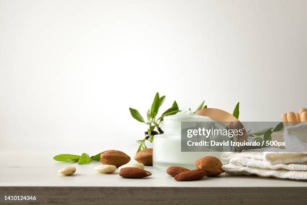 moisturizing cream with almond extract on wooden table isolated white - almond oil stockfoto's en -beelden