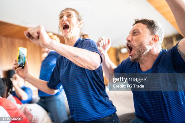 sports fans celebrating while watching a match at a house - french tv stock pictures, royalty-free photos & images