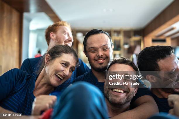 freunde von sportfans, die sich ein spiel ansehen und zu hause feiern - geistige behinderung stock-fotos und bilder