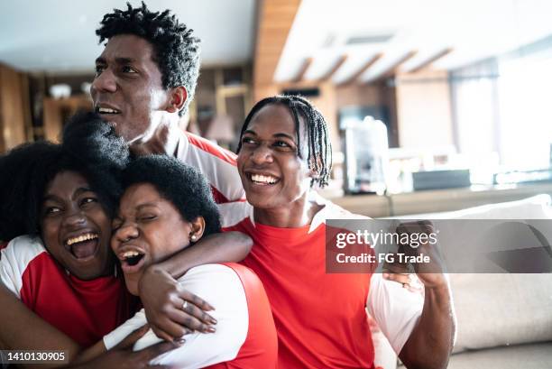 amis fans de sport regardant un match et célébrant à la maison - tenue de football photos et images de collection