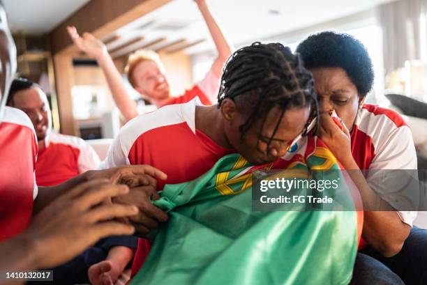 portuguese sports fan watching a match and celebrating at a house - social tv awards stockfoto's en -beelden