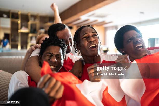 canadian sports fans celebrating while watching a match at home - hockey fans stock pictures, royalty-free photos & images