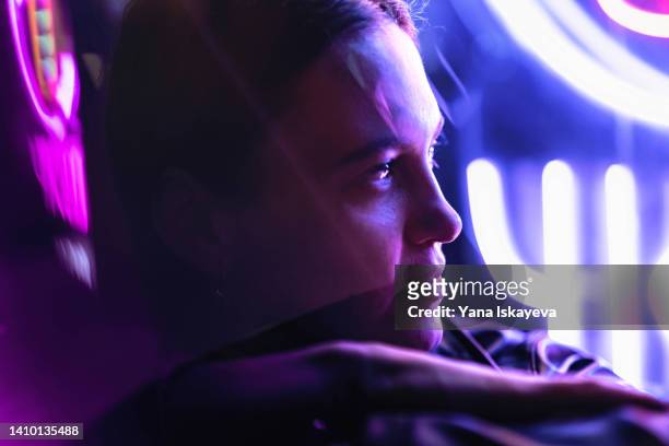 progressive woman at night in purple, pink, and very peri neon lights - science fiction stock-fotos und bilder