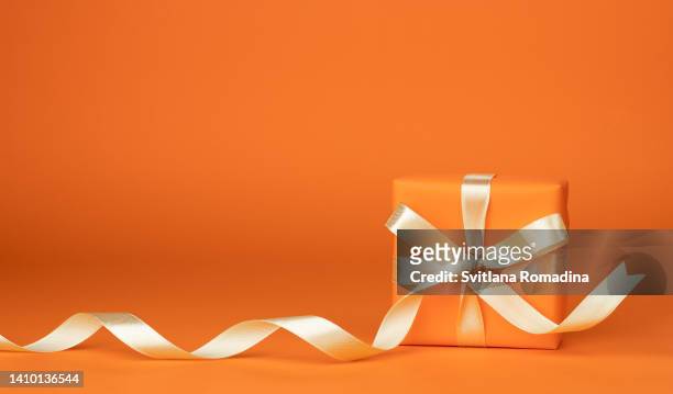 holiday gift box on orange background with copyspace - birthday present photos et images de collection