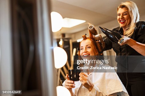 Hairdresser making a curl with hair dryer Hairdresser making a curl with hair dryer
