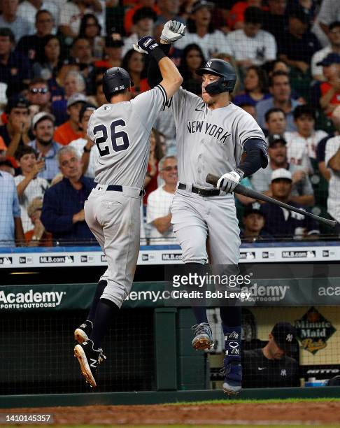 LeMahieu of the New York Yankees receives a high five from Aaron Judge after hitting a solo home run in the fifth inning against the Houston Astros...