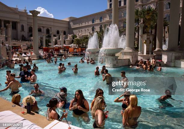 People cool off in the 110 degree heat at Temple Pool, one of seven pools at the Caesars Palace Garden of the Gods Pool Oasis, as viewed on July 15,...