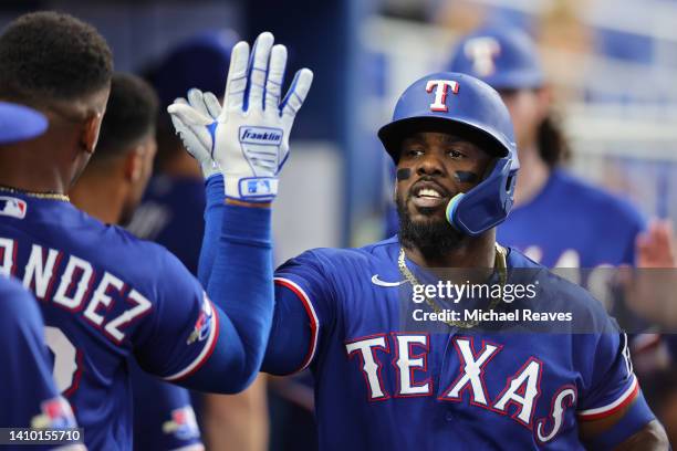 Adolis Garcia of the Texas Rangers celebrates with teammates after hitting a two-run home run against the Miami Marlins during the fifth inning at...