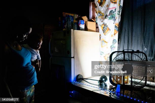 Yvette Johnson, who goes by Tootie, holds her child near a window fan in her home during a heatwave on July 21, 2022 in Houston, Texas. "Its too much...