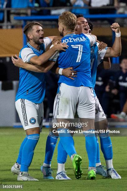 Teammates surround Kamil Jówiak of Charlotte FC after he scores winning penalty shot during a game between Chelsea FC and Charlotte FC at Bank of...