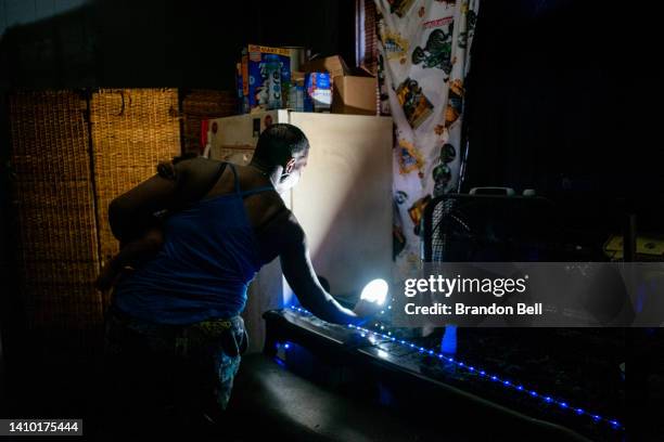 Yvette Johnson, who goes by Tootie, reaches to turn off a light in her home during a heatwave on July 21, 2022 in Houston, Texas. "Its too much heat...