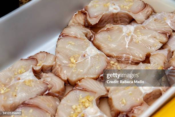 raw dogfish steaks seasoned with minced garlic, close-up. - dogfish stock pictures, royalty-free photos & images