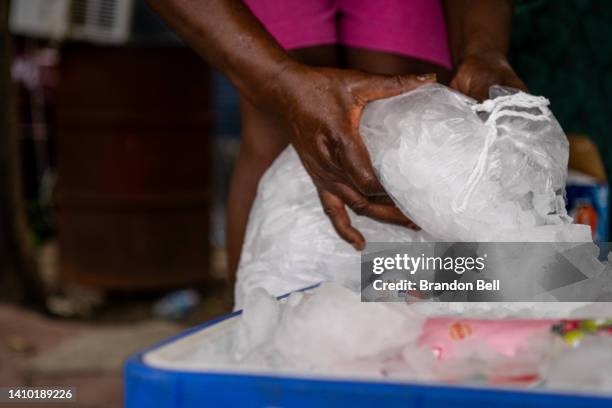 Brenda Puritt fills an ice chest outside of her family's home during a heatwave on July 21, 2022 in Houston, Texas. Excessive heat warnings have been...