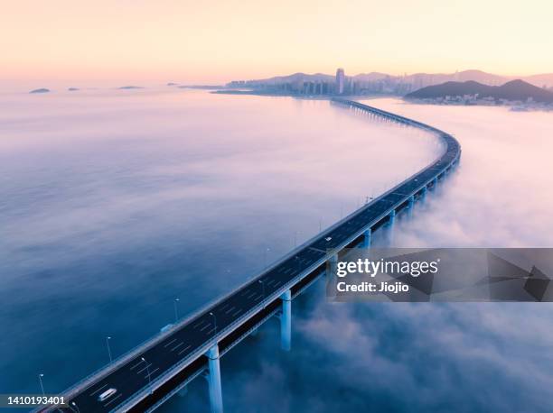 cross-sea bridge in fog - majestic city stock pictures, royalty-free photos & images