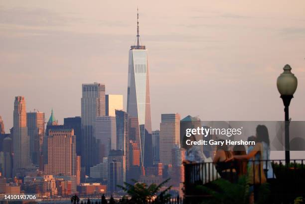 People stand in front of the skyline of lower Manhattan and One World Trade Center in New York City on July 21 as seen from Weehawken, New Jersey.