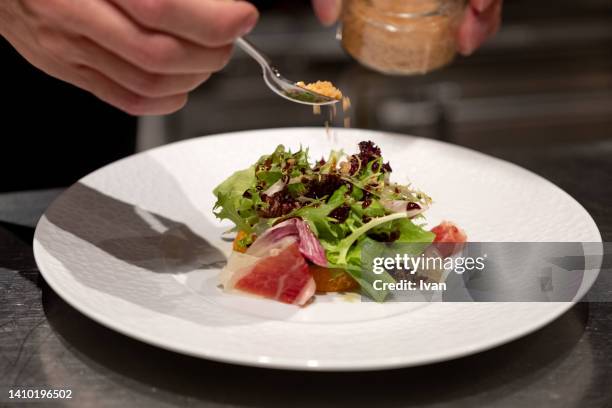 chef making fresh green salad with olive oil and iberico jamon - side salad - fotografias e filmes do acervo