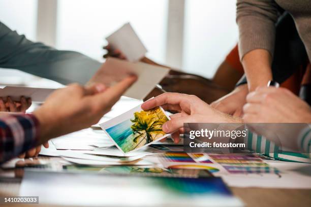 sorting out photographs for a new mood board for upcoming photoshoot - grafisch ontwerpbureau stockfoto's en -beelden