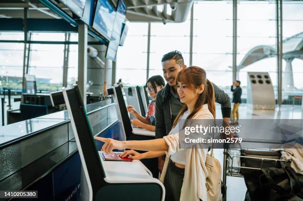 shot of asian chinese couple using touch screen display to confirm identity in airport terminal, travel, technology, - portraits of people passport imagens e fotografias de stock
