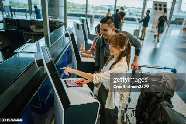 casal asiático usando quiosque de check-in automatizado no aeroporto - security scanner - fotografias e filmes do acervo