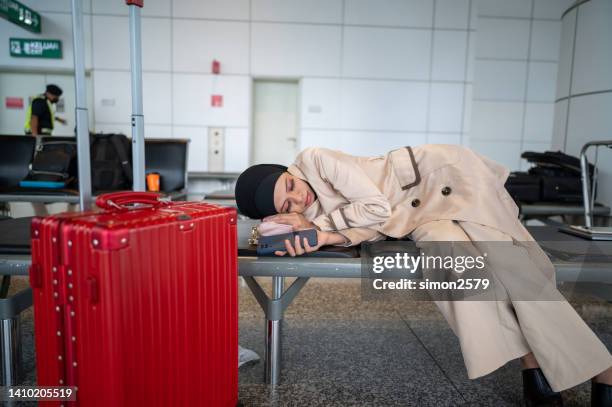 young asian female traveler sleeping at airport - jet lag stockfoto's en -beelden