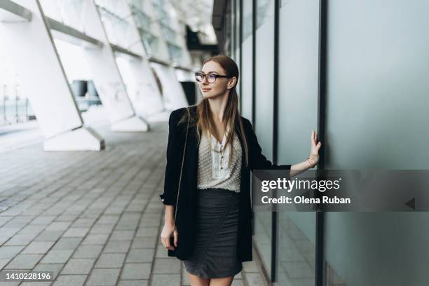 young woman touching matte glass wall. - black skirt stockfoto's en -beelden