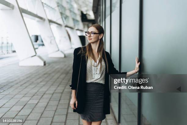 young woman touching matte glass wall. - black skirt stock pictures, royalty-free photos & images