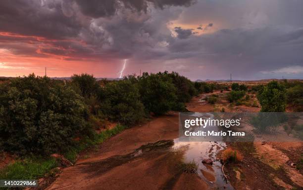 Lightning strikes during a monsoon storm with a nearly dry creek bed in the foreground on July 21, 2022 near Mayer, Arizona. The National Weather...