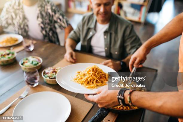 two gay couples sitting on a table to have lunch - kochen freunde stock-fotos und bilder