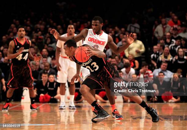 Sean Kilpatrick of the Cincinnati Bearcats looks to dribble around Dion Waiters of the Syracuse Orange during the semifinals of the Big East men's...