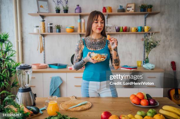 woman eating a healthy fruit salad at home - fruit salad stock pictures, royalty-free photos & images