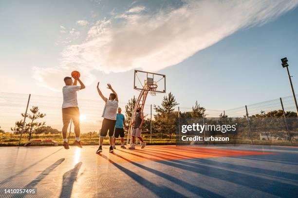 friends playing basketball outdoors - basketball blocking shot stock pictures, royalty-free photos & images