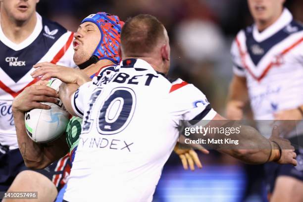 Kalyn Ponga of the Knights is tackled by Matthew Lodge of the Roosters during the round 19 NRL match between the Newcastle Knights and the Sydney...