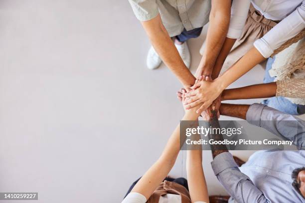 empresarios diversos de pie juntos con las manos apiladas - hands clasped fotografías e imágenes de stock