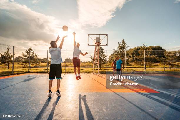 amigos jugando al baloncesto al aire libre - marcar términos deportivos fotografías e imágenes de stock