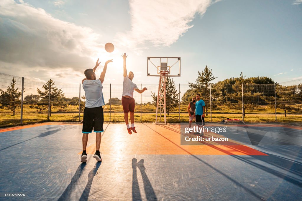 Friends Playing Basketball Outdoors