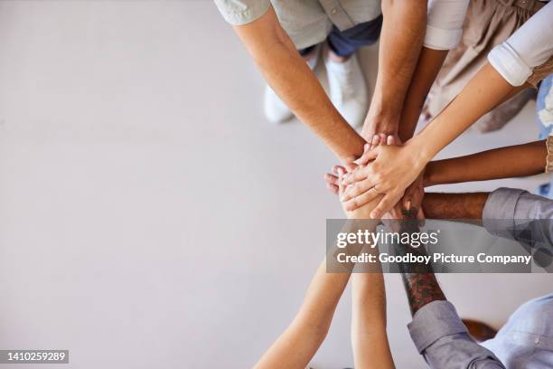 diverse businesspeople standing with their hands stacked together - briefing stockfoto's en -beelden