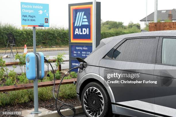 An electric car charges in the car park at the new Tarleton Aldi store on July 22, 2022 in Tarleton, United Kingdom. Aldi is the UK’s fifth largest...