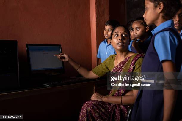 teacher teaching students in a classroom on desktop pc - indian girl pointing stock-fotos und bilder