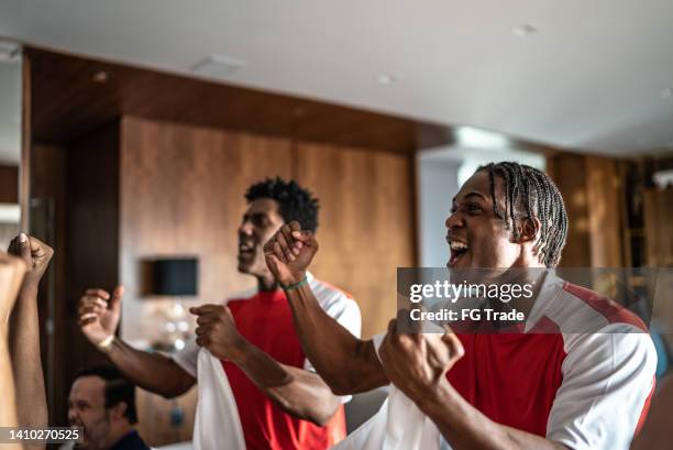 sports friends fans watching a match and celebrating at a house - social tv awards stockfoto's en -beelden