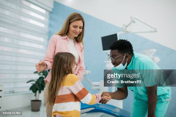 junge erwachsene mutter mit ihrer tochter in der zahnarztpraxis - pediatric dentistry stock-fotos und bilder