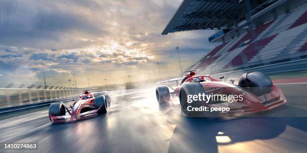 two race cars moving at high speed in slightly wet conditions - sports track stockfoto's en -beelden