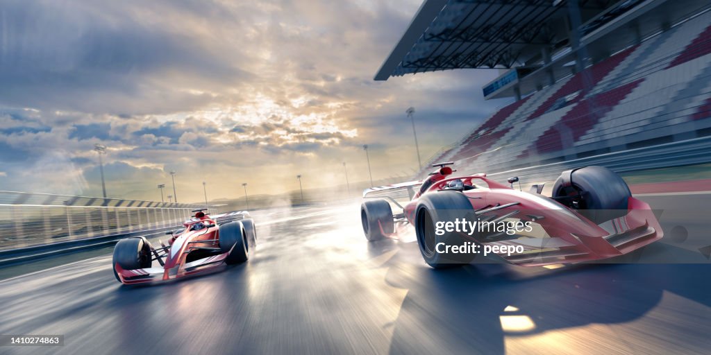 Two Race Cars Moving at High Speed in Slightly Wet Conditions