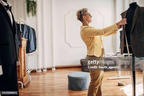 female tailor making a suit - custom tailored suit stock pictures, royalty-free photos & images