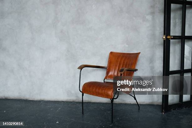 the interior of the living room with a leather armchair or armchair against a gray wall. the concept of minimalism. home improvement. - shabby chic stock pictures, royalty-free photos & images