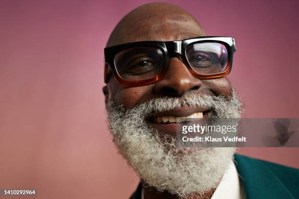 portrait of senior man wearing eyeglasses - teal portrait stockfoto's en -beelden