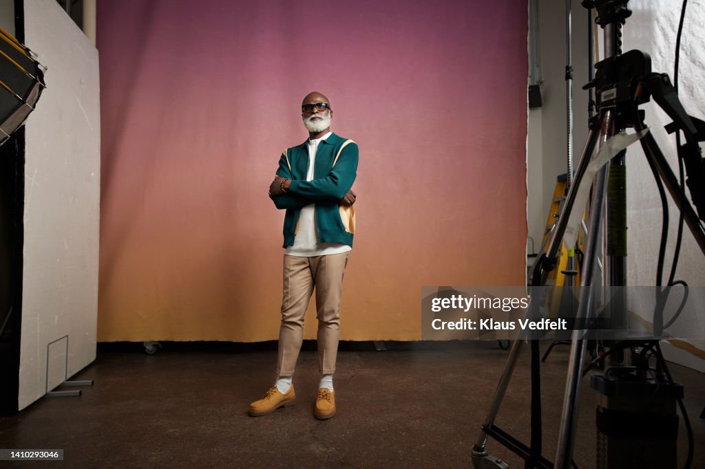 Confident senior man with arms crossed in photo studio